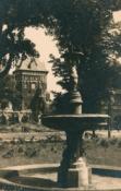 Zdjęcie z ok. 1950 r. przedstawiające fontannę, w tle Brama Wyżynna i Katownia