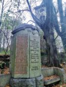 Odrestaurowany pomnik mieszkańców Płóczek poległych w I wojnie, w tle dzwonnica